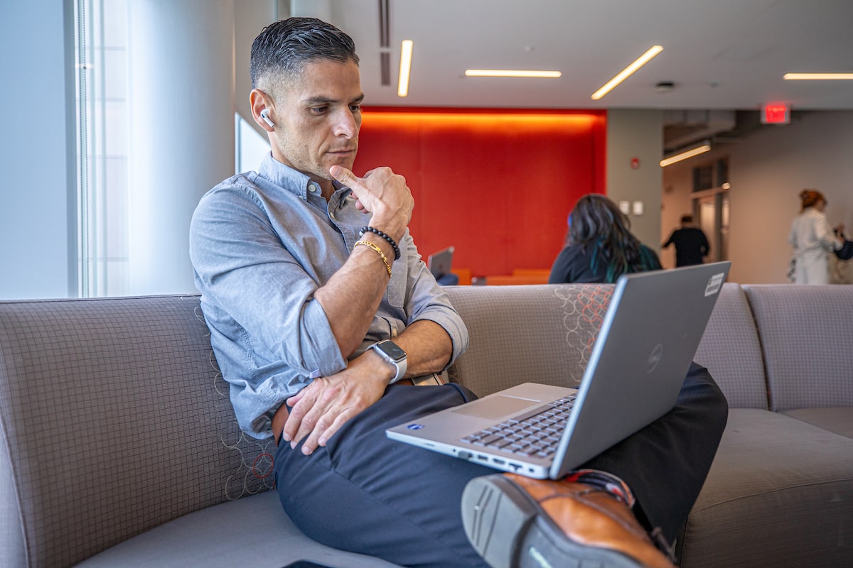 man sitting and looking at laptop