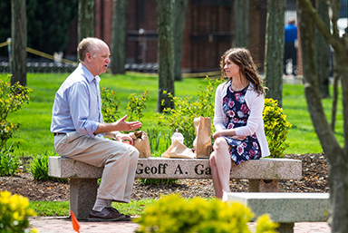 A man and a woman talking while sitting on a bench