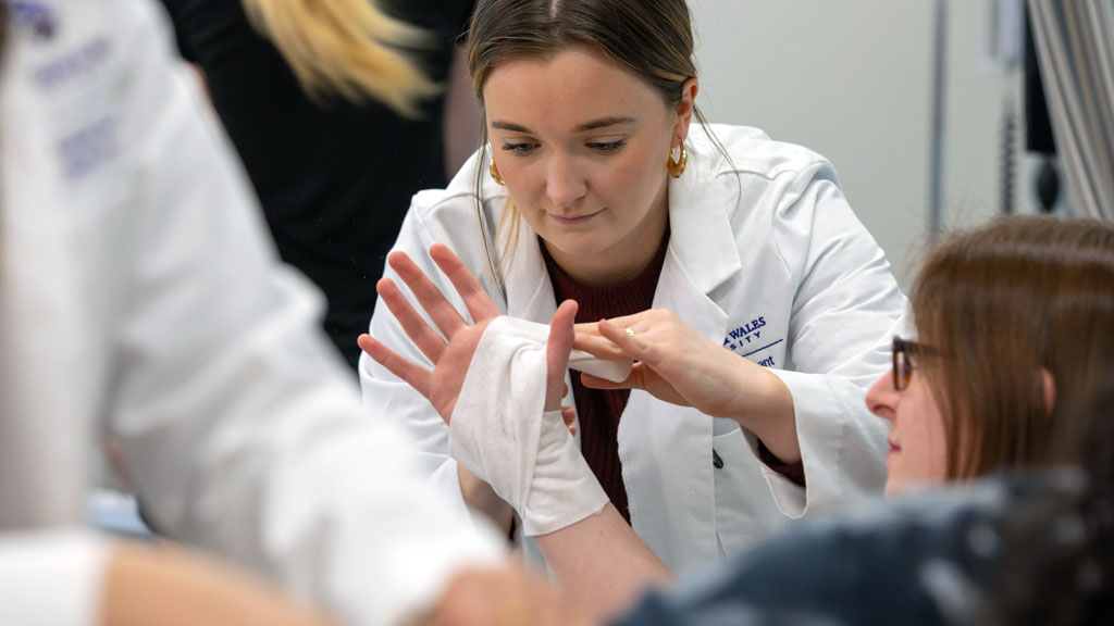 PA student practicing bandage wrapping in the clinical practice space.
