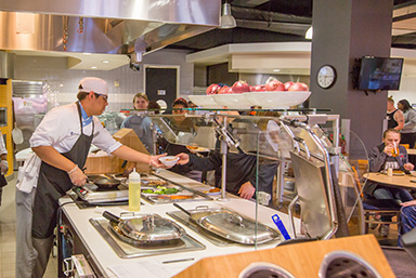 JWU Charlotte Dining Facility. Chef serving food to students