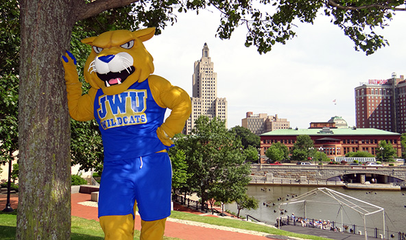Wildcat Willie standing in front of providence waterfire - an event that takes place often in the city of Providence