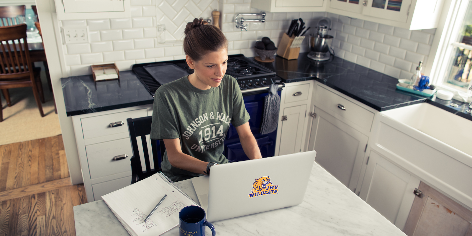 JWU Student at home taking class in kitchen