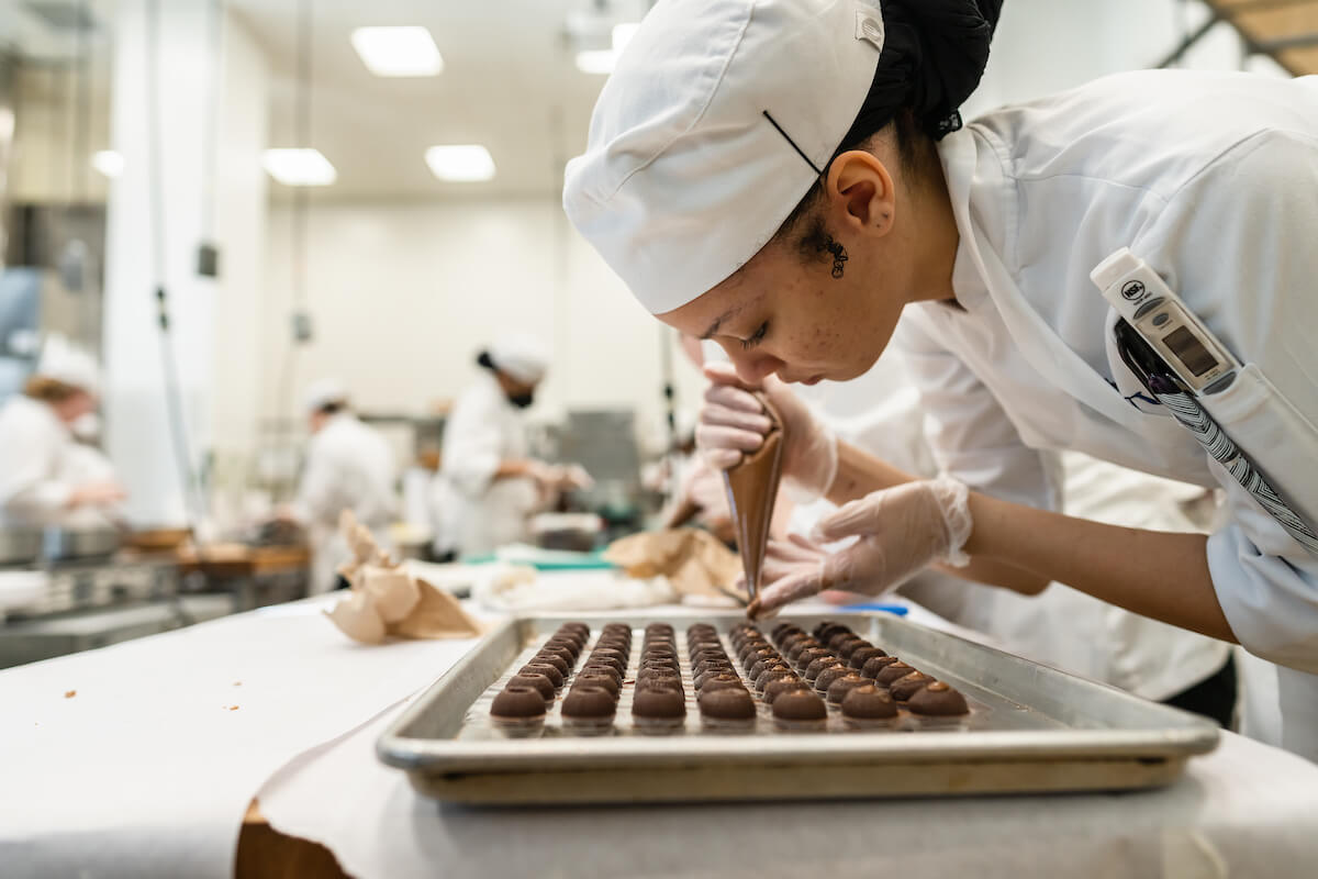 young female pastry chef making chocolates