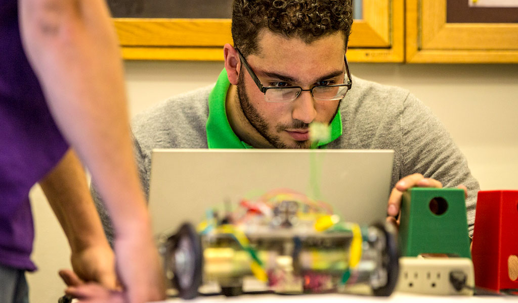 Enigineering students at work on laptops.