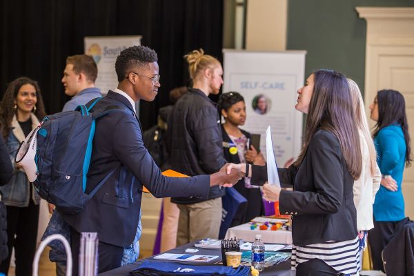 student and vendor shaking hands at career fair