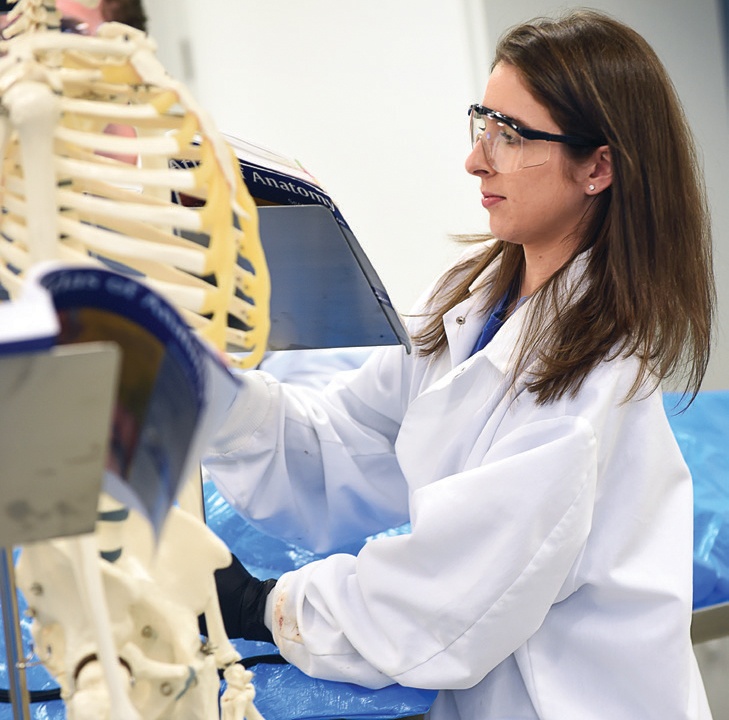 PA STUDENT MONICA SOUZA AT WORK IN THE GROSS ANATOMY LAB. PHOTO