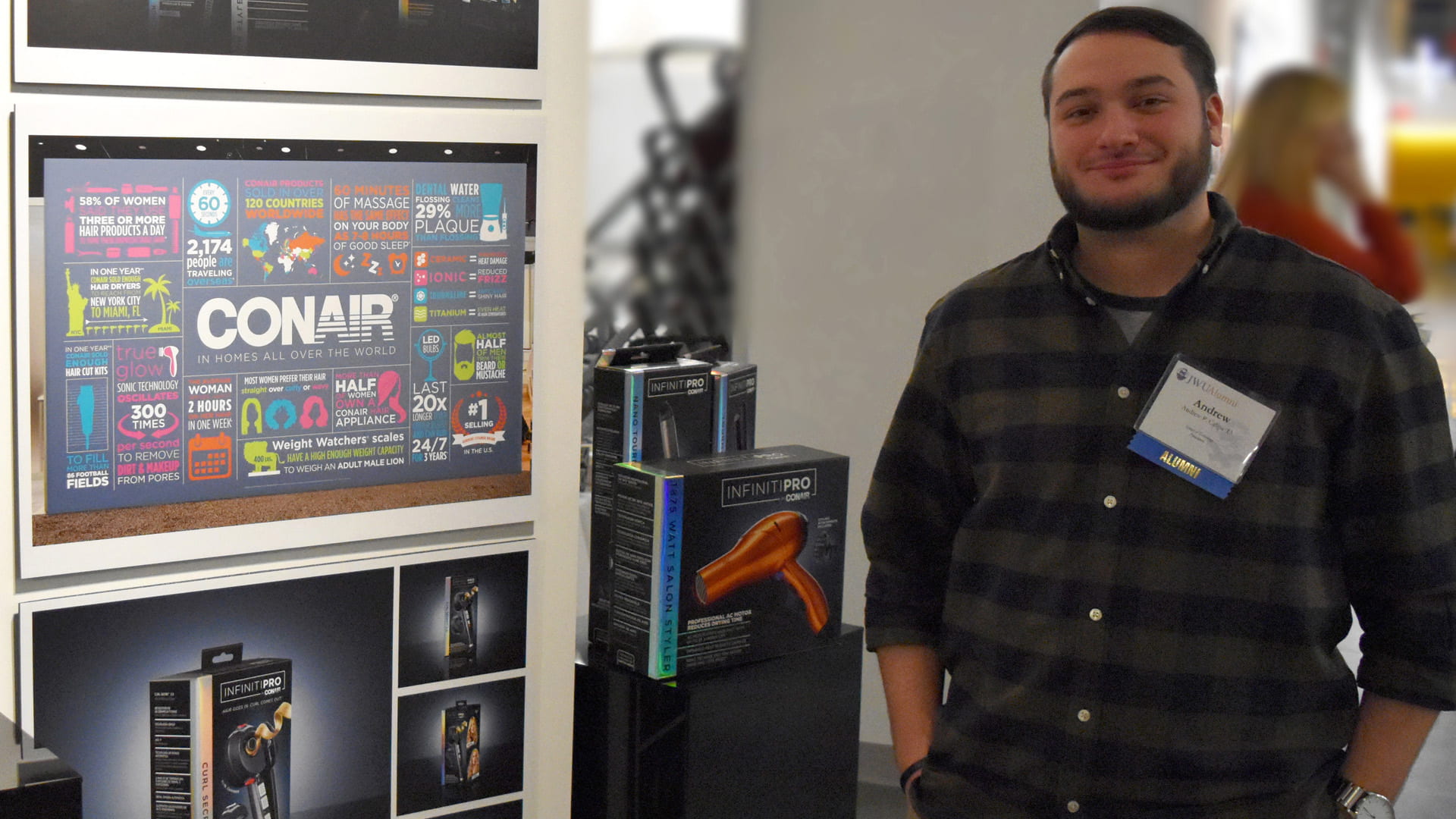 Andrew Calipa '13 poses with his package redesign display for the InfinitiPRO by Conair.