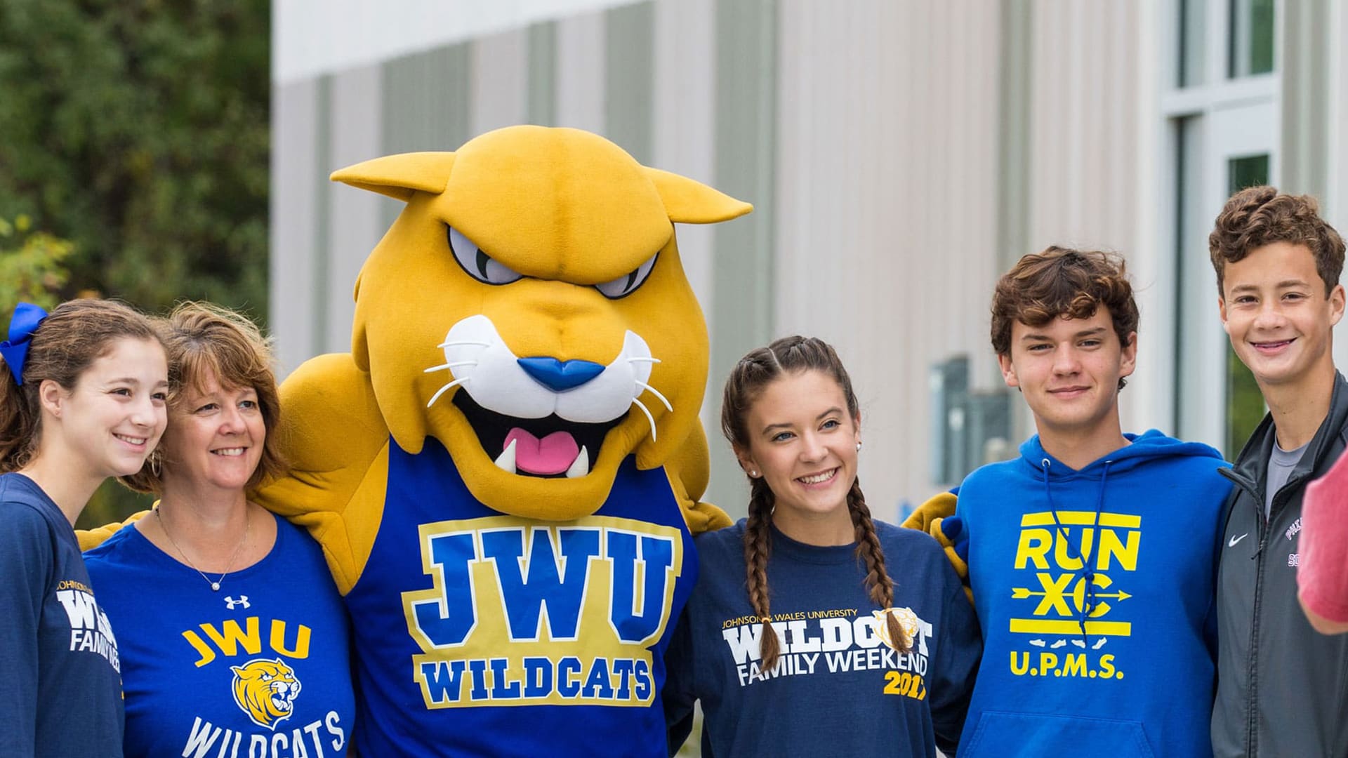 Family posing with Wildcat Willie for a photo