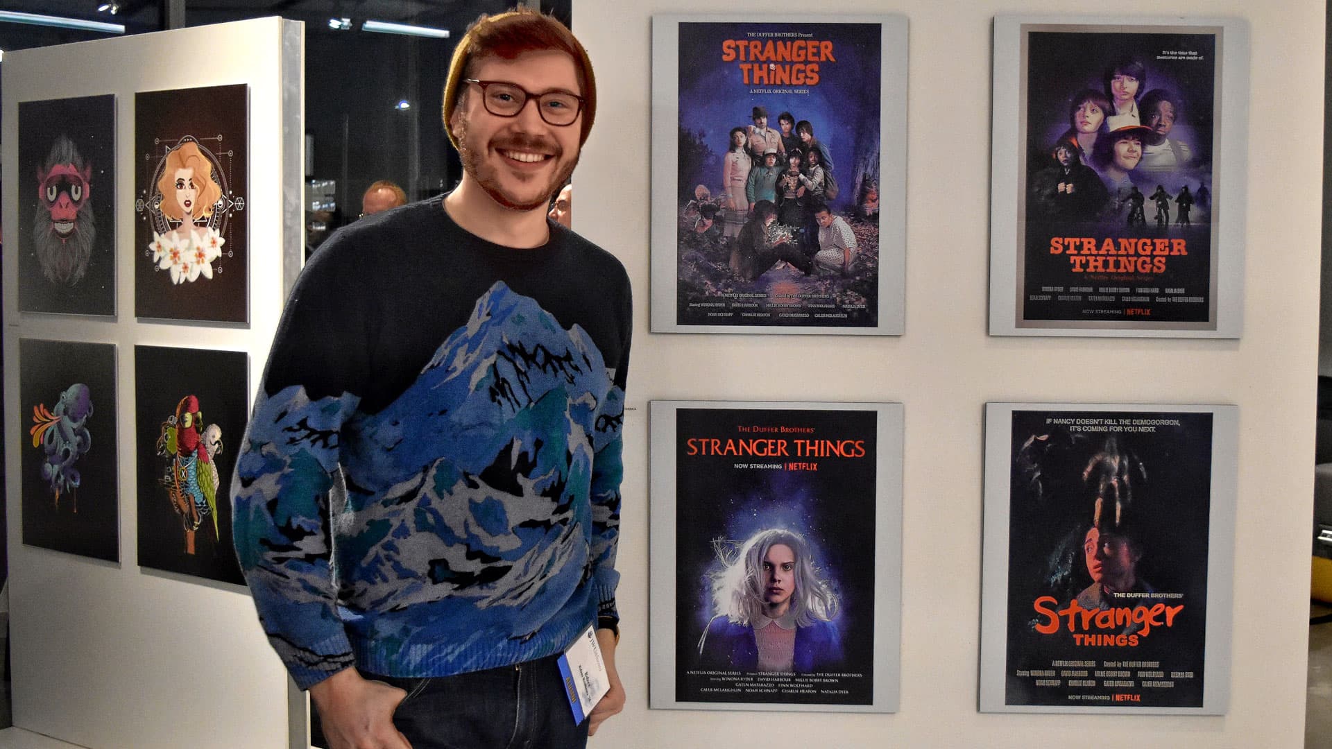 JWU alum Edzer Roukema in front of his poster series for the Netflix series, “Stranger Things”