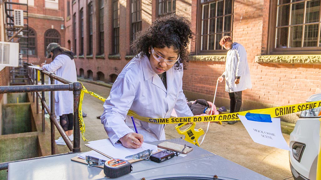 A JWU Criminal Justice student working in a mock crime scene 