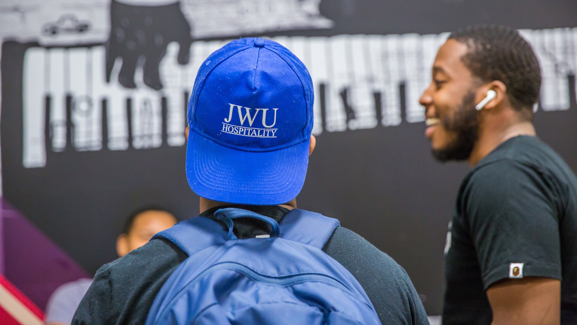 Back view of student wearing a JWU Hospitality hat