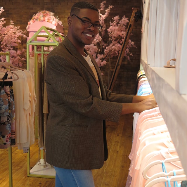 Derrick Tre arranges clothes at Captivate, the SouthPark Mall boutique where he is a manager.