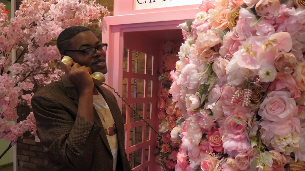 Derrick Tre '17 at the rose-covered phone booth at Captivate.