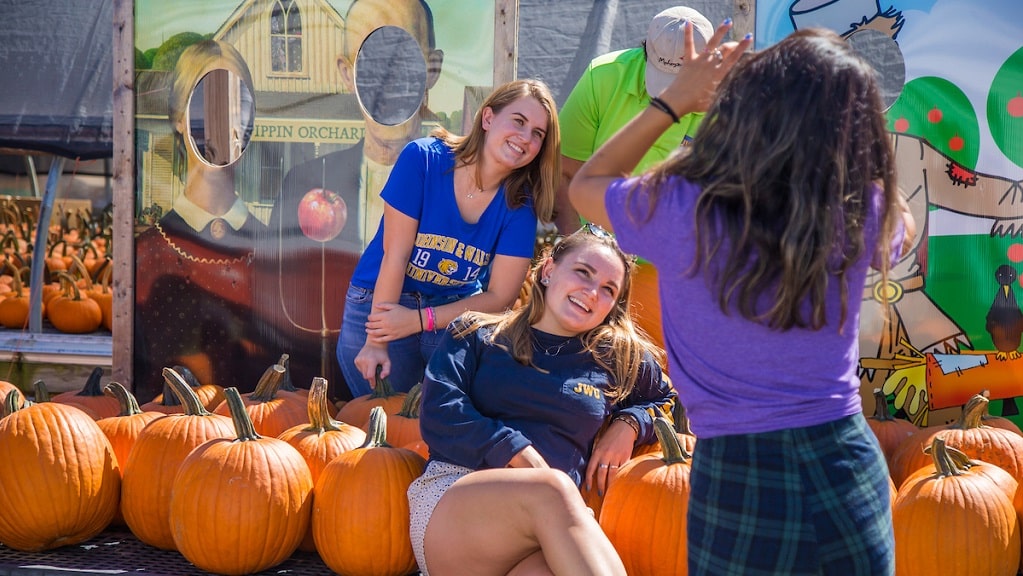 Three students pose for picture at pumpkin patch