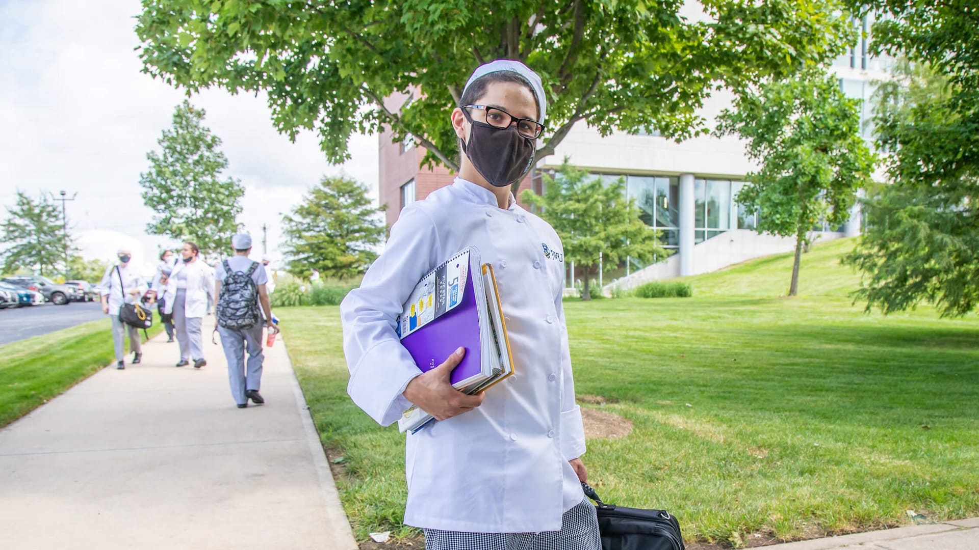 culinary student holding books at JWU