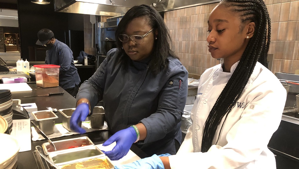 JWU alumni and student work together in kitchen at Marriot