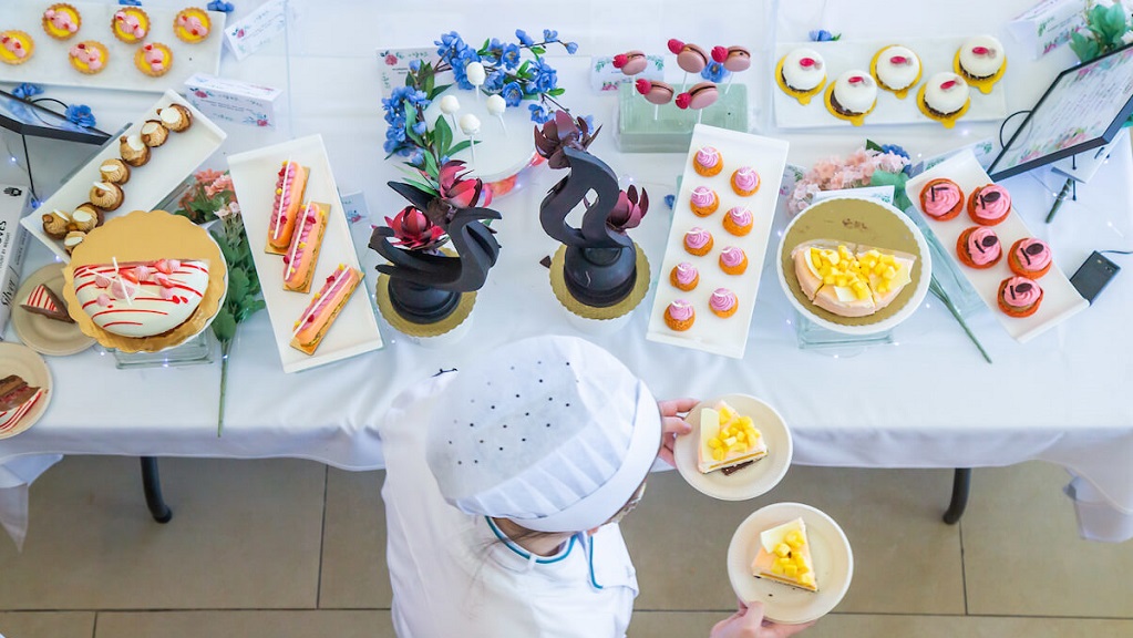 bird's eye view of culinary student carrying desserts