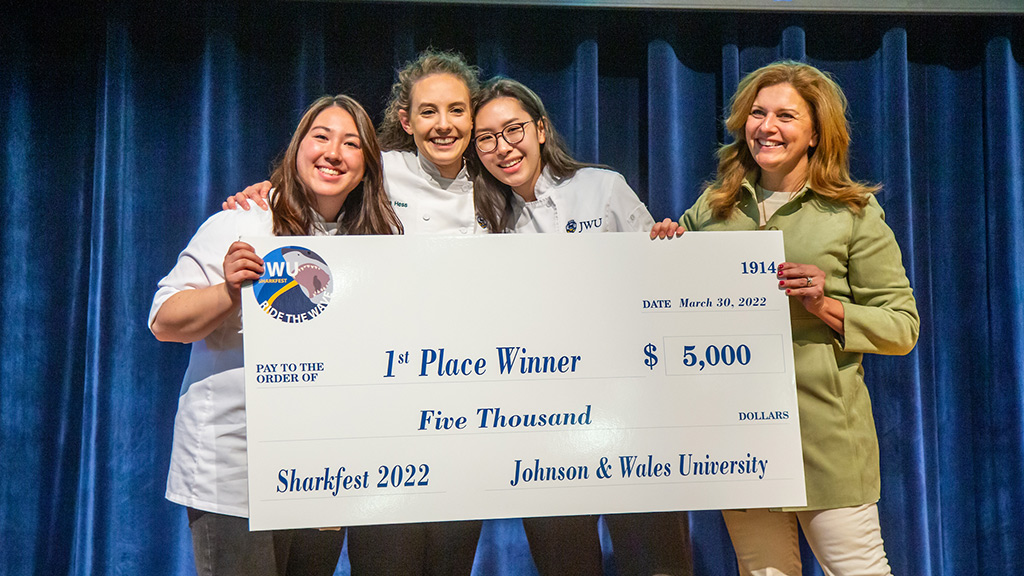 The 2022 JWU Sharkfest first place winners with their prize check presented by Providence Campus President Marie Bernardo Sousa