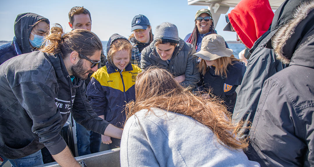 Sustainable Food System students learn the art of quahogging on the ocean on Earth Day 2022