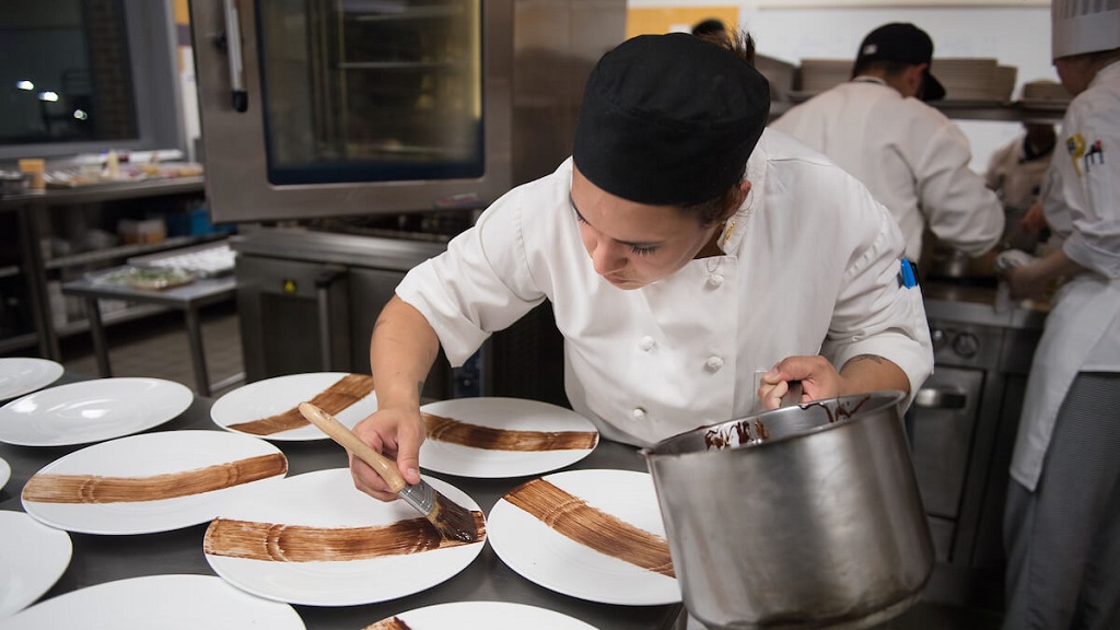 culinary student preparing chocolate dessert plating 