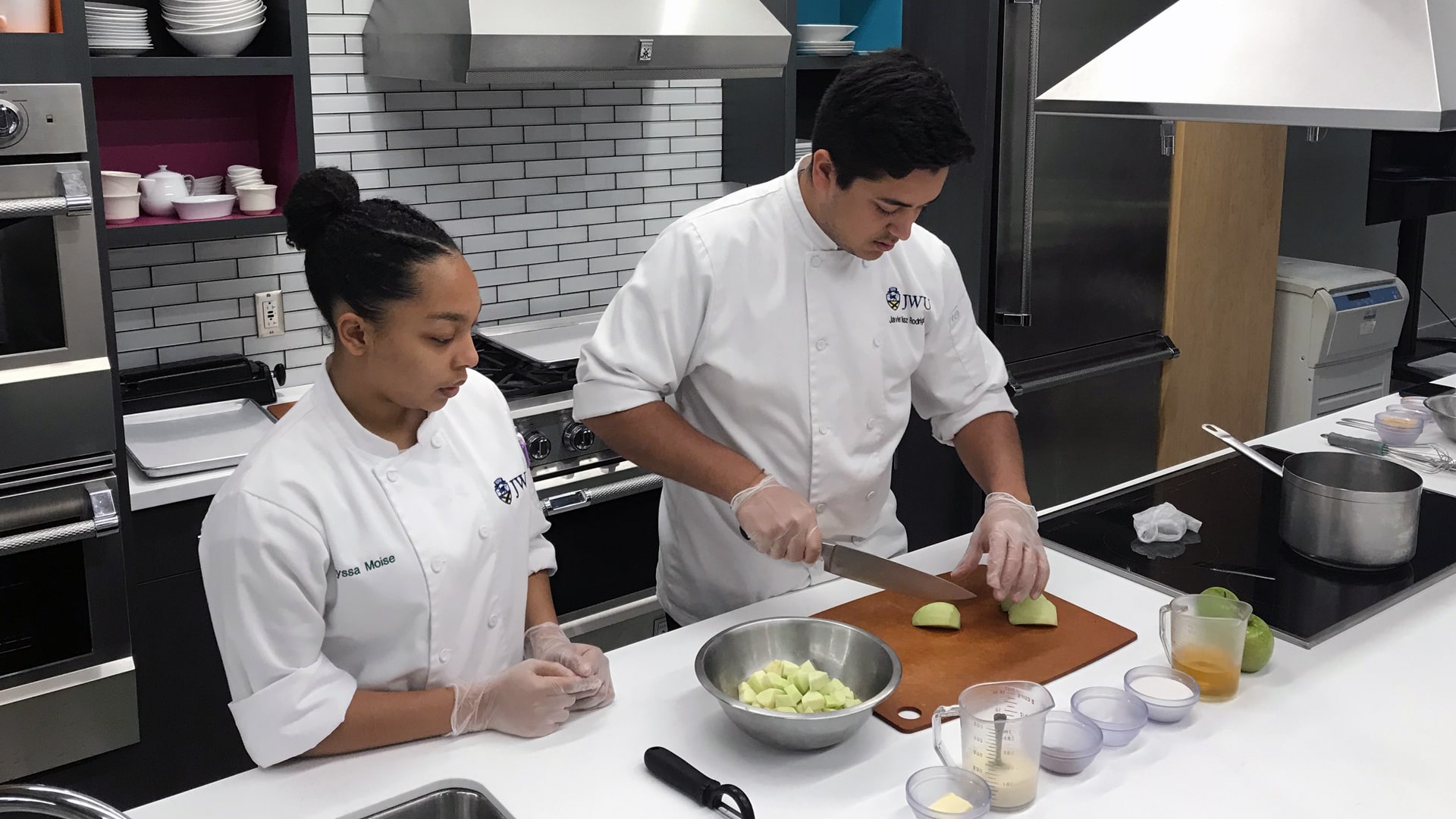 Javier Rodriguez and Alyssa Moise prepping apple pie filling in the FIDL kitchen.