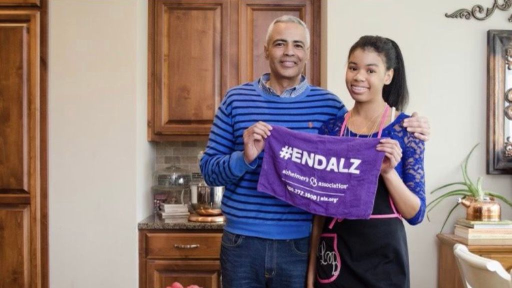 Morgan and her dad hold a purple alzheimer's banner