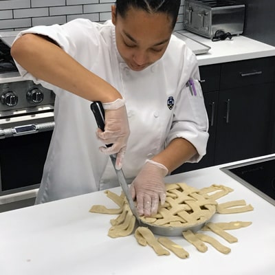 Alyssa Moise trims the pie before it goes in the oven.