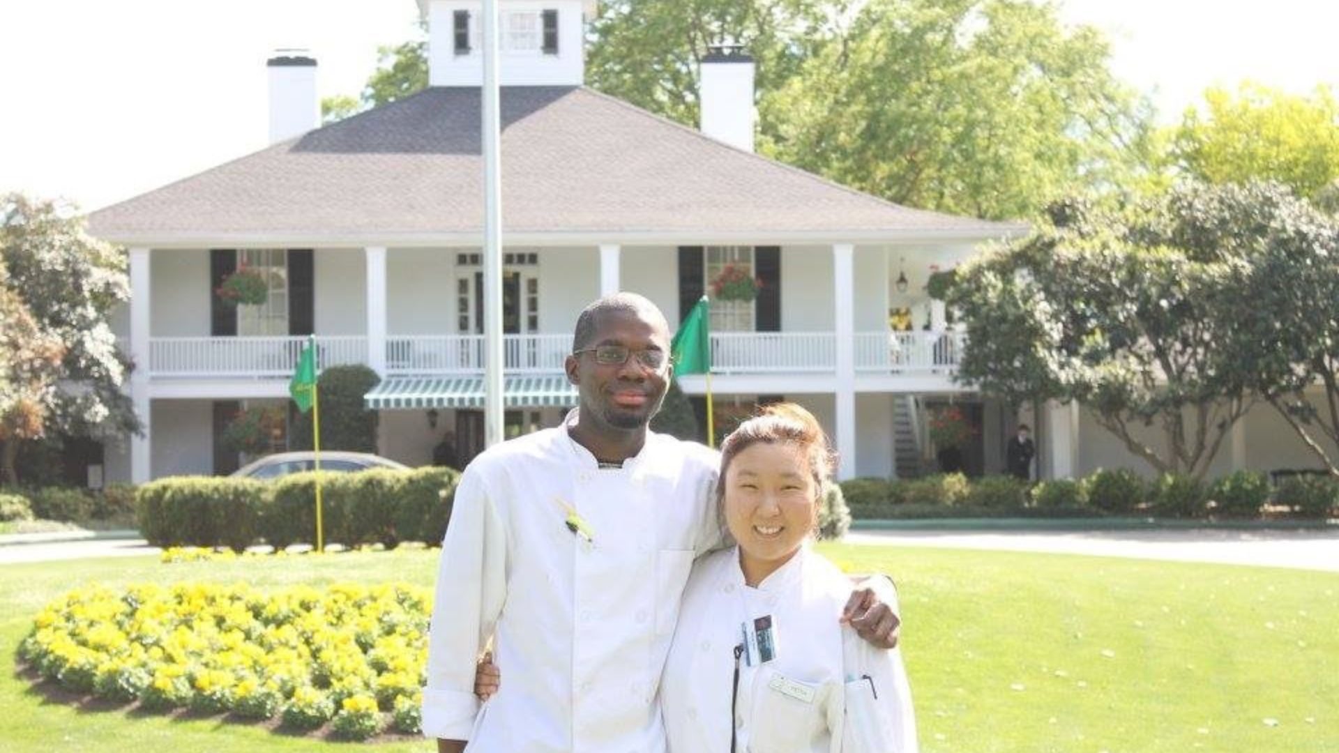 Two students stand in front of the Augusta National clubhouse