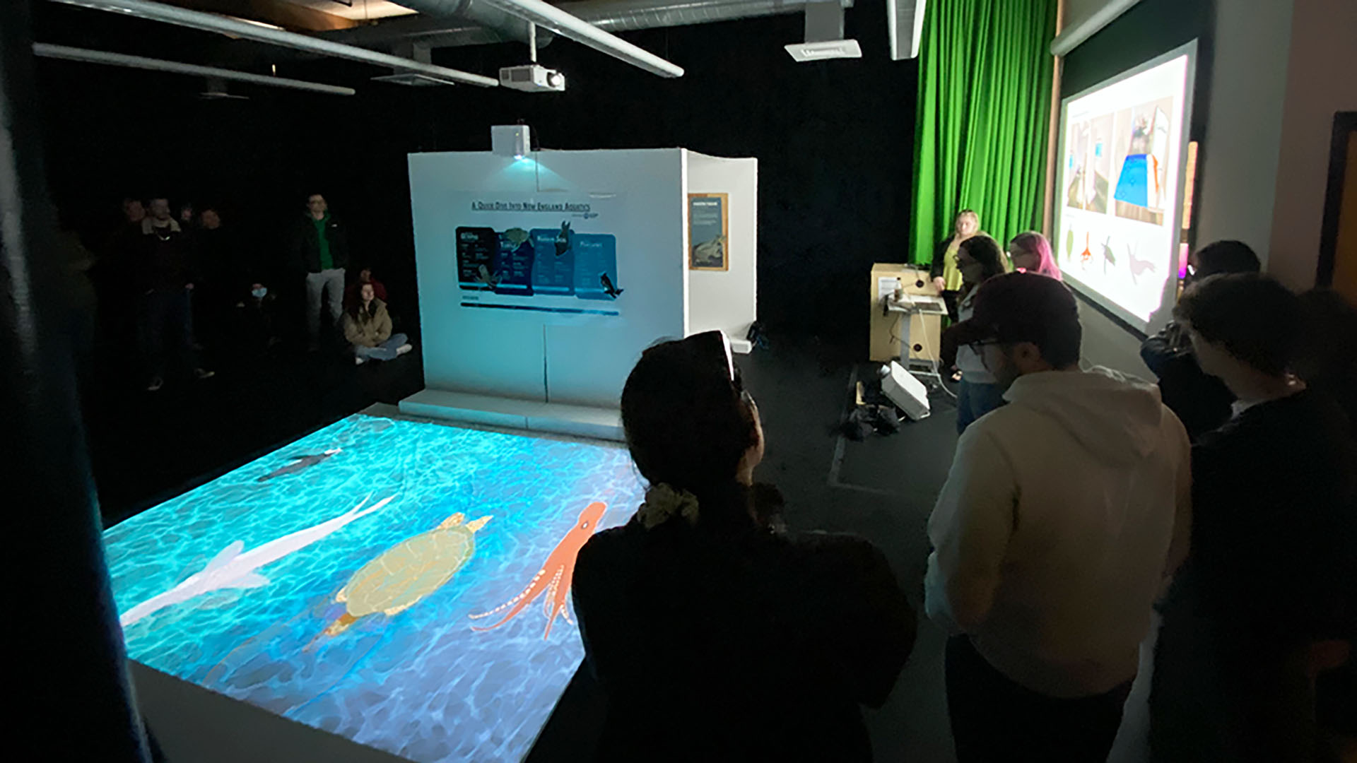 Students watch a projection on the floor of the Center for Media Production