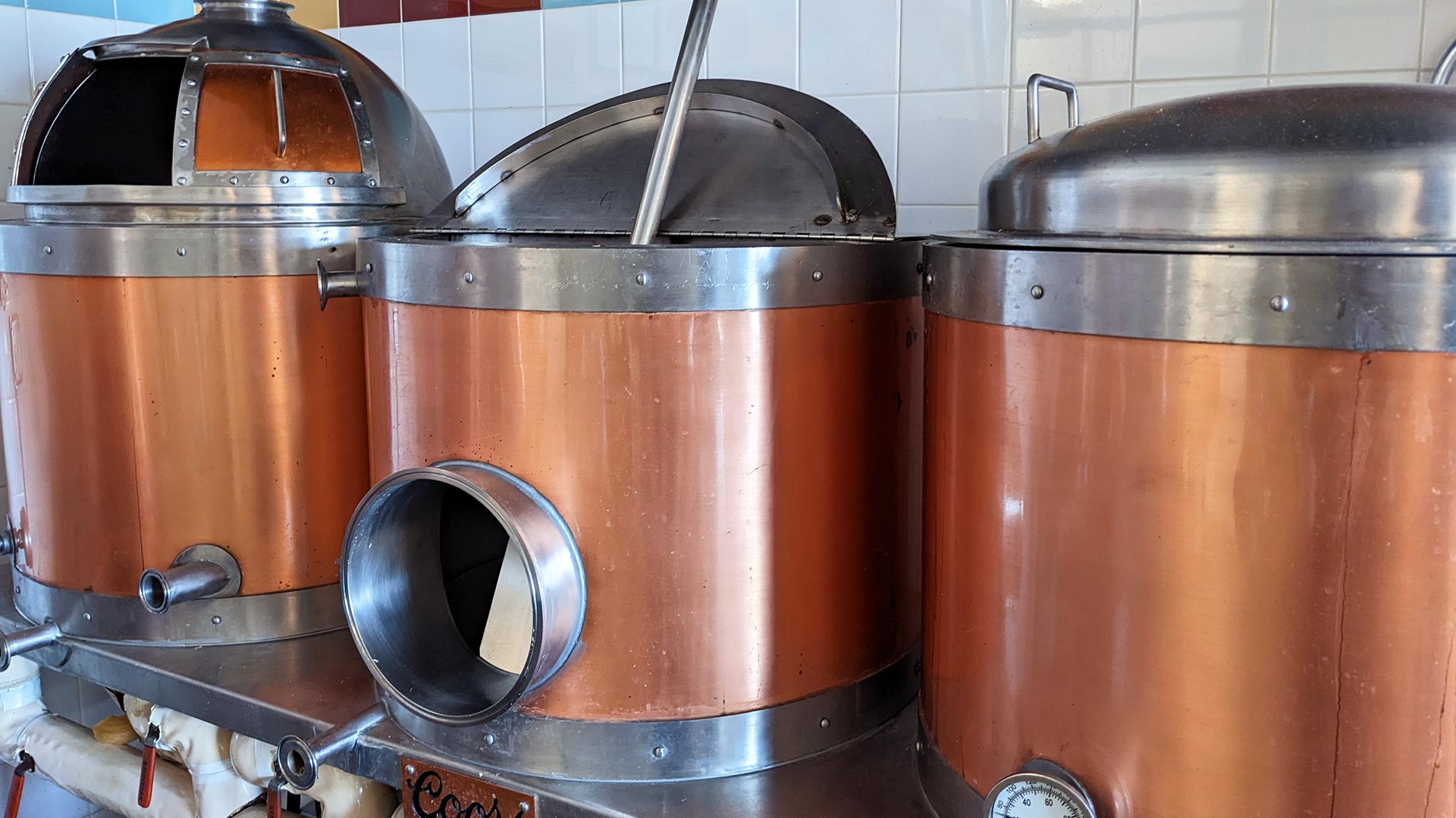 photo of three shiny copper beer kettles that are used in JWU craft brewing programs