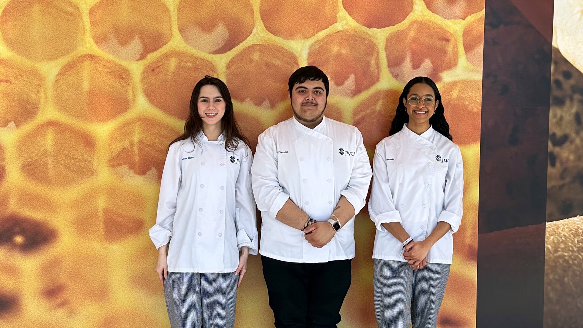 Vanessa Mello, Josue Cervantes and María Hernández in the hallway of the Cuisinart Center for Culinary Excellence at JWU Providence.