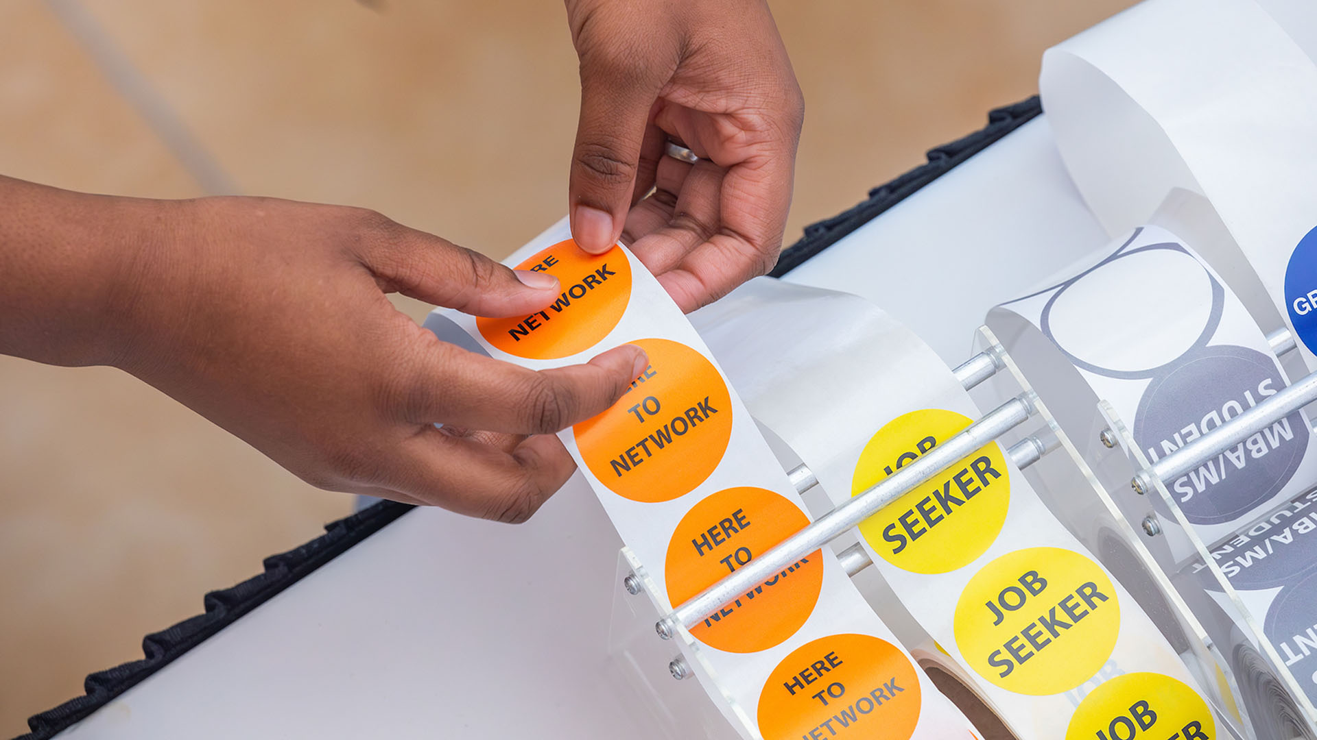 A person's hands reaching for an orange sticker that says "networking"