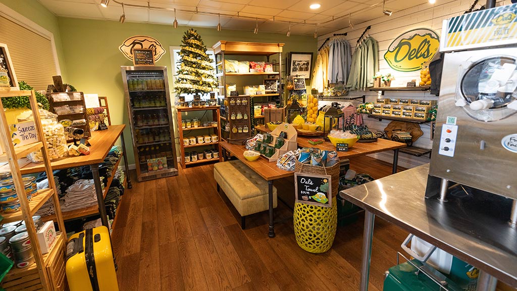 a photograph taken inside a gift shop, featuring a variety of Del’s Lemonade-branded clothing and products