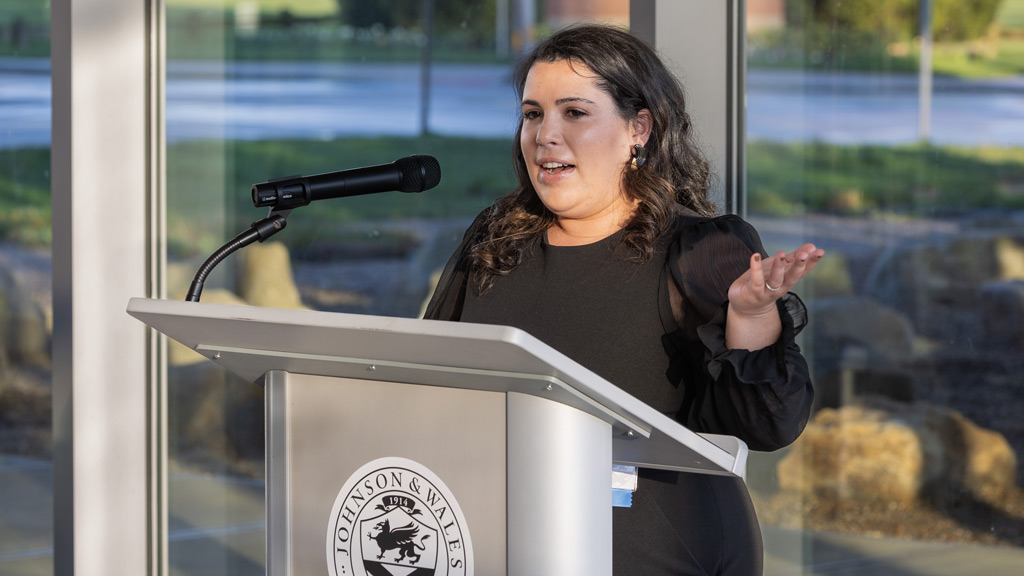 photo of Maggie Mulvena Pearson '13 speaking at a podium