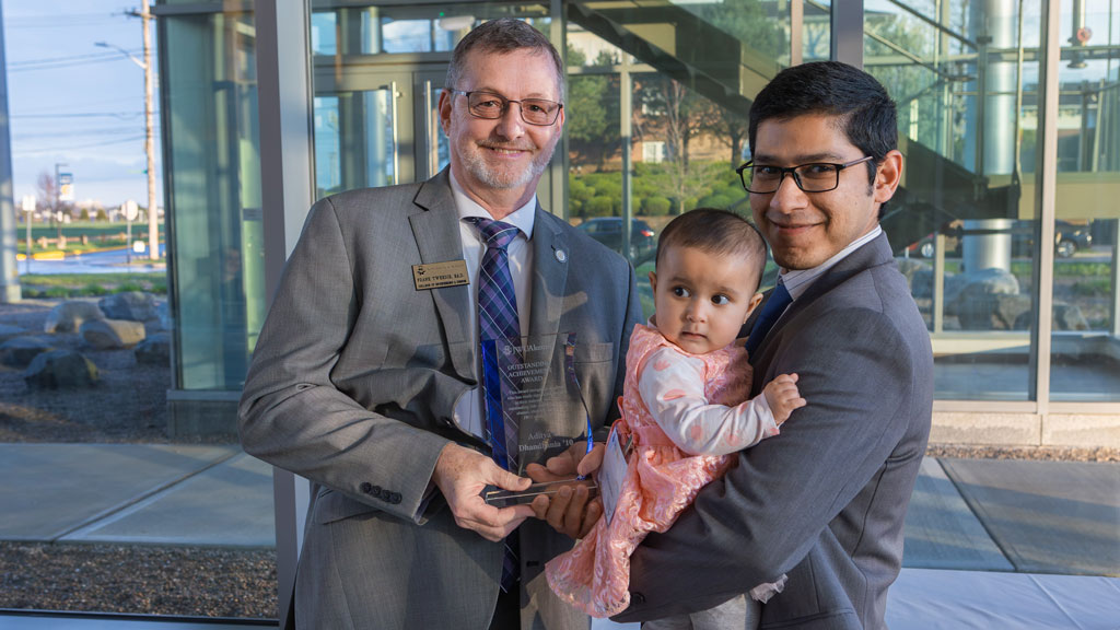 photo of Dean Frank Tweedie ’95, Ed.D., and Adi Dhandhania ’10, who is holding a baby girl
