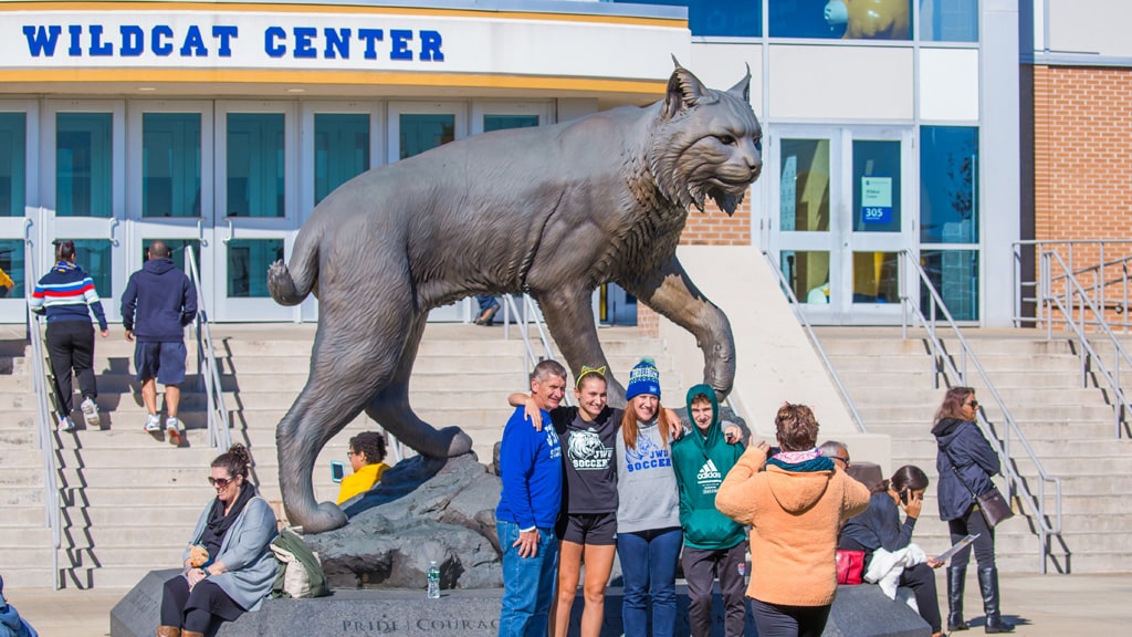 Students and families pose with Wildcat statue on Harborside Campus