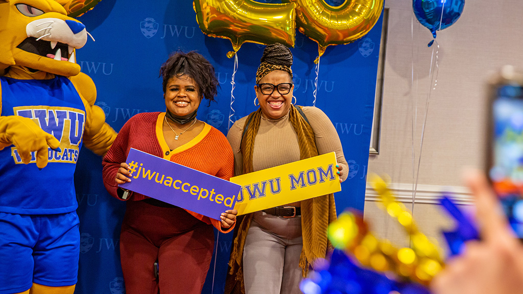 A mother and daughter pose with Wildcat Willie on Accepted Students Day