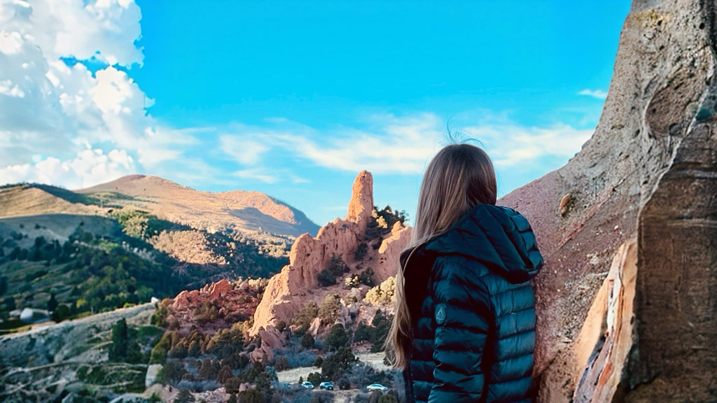 a photo taken from behind of a woman enjoying Utah scenic views