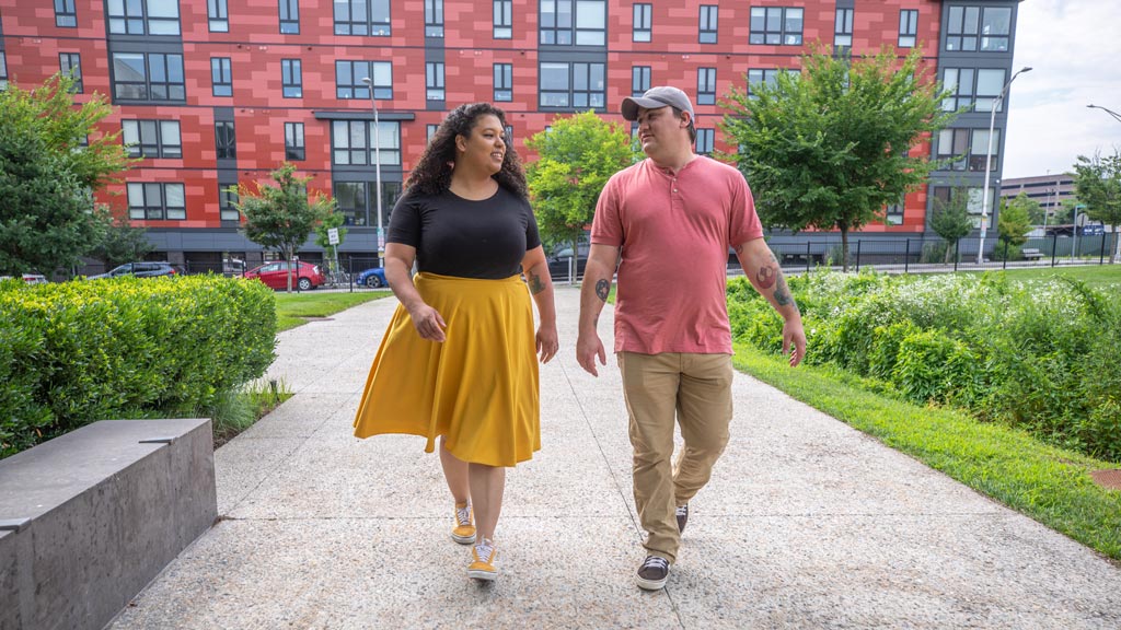 a man and woman walk while talking outside of JWU's Bowen Center