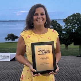 a photo of Rebecca Simon holding up her PBN award