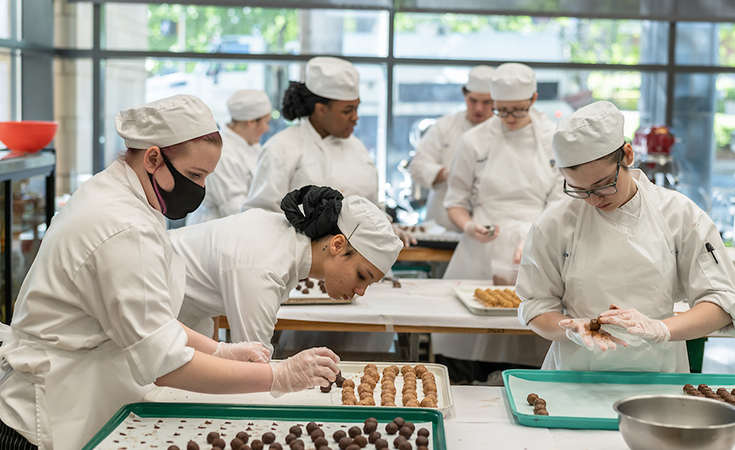 JWU Charlotte Students baking during a lab.