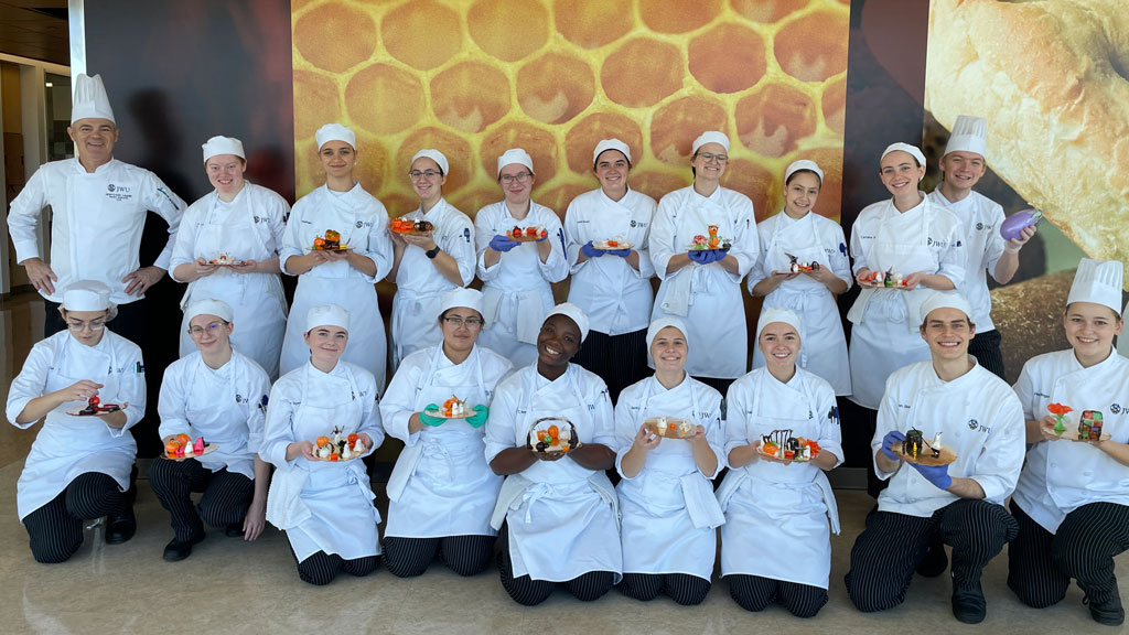 a group photo of Pastry Arts Club members posing with their sugar art