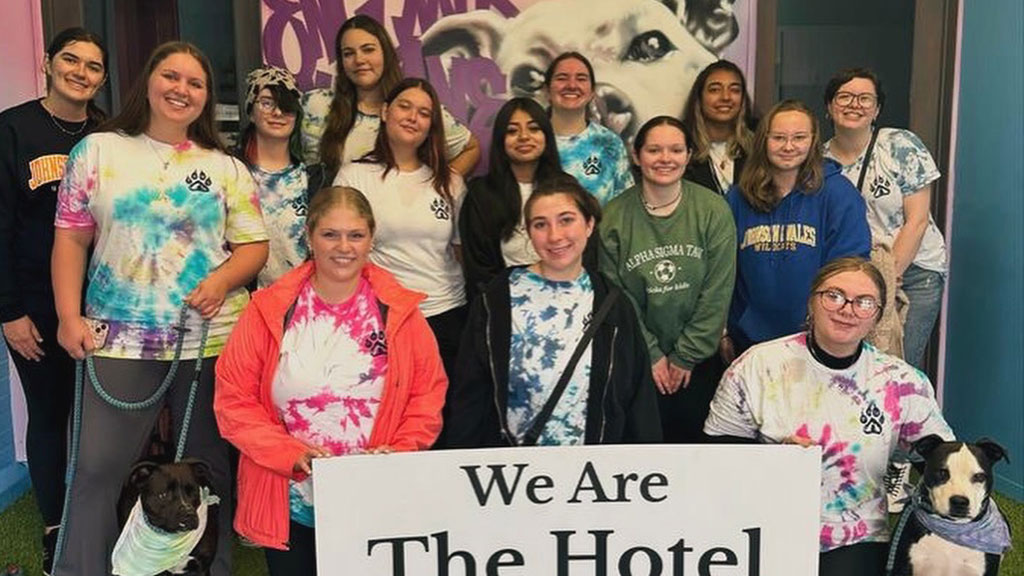 a group photo of JWU P.A.W.S. club members posing at the Hotel for Hounds