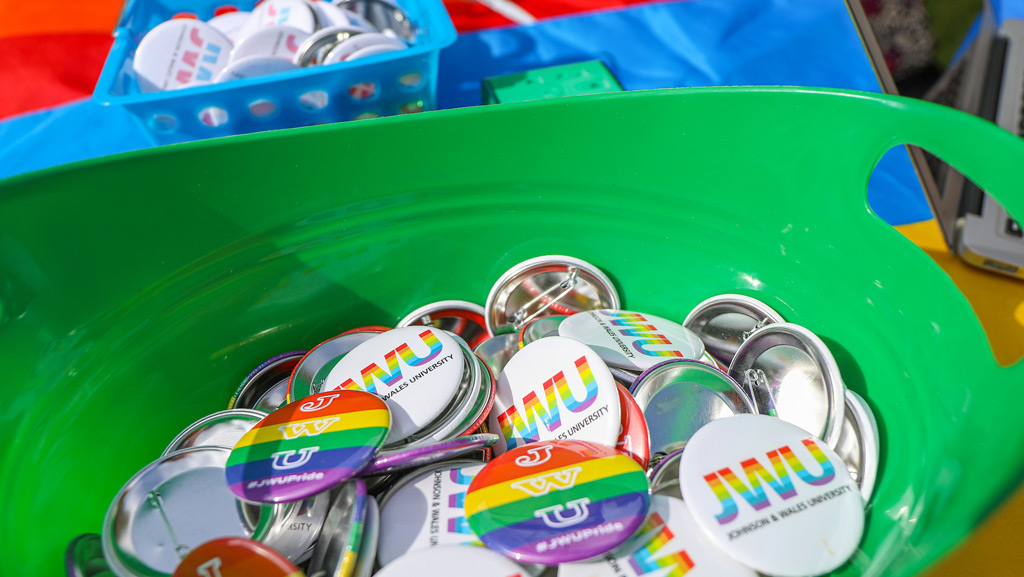 a closeup photo of JWU pride pins inside of a basket