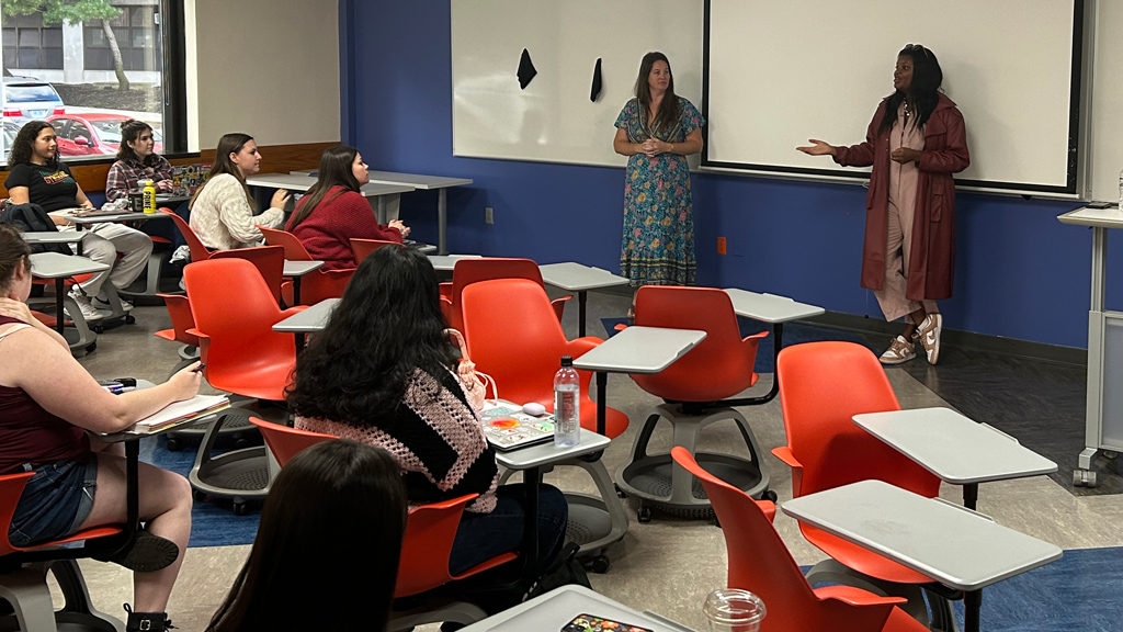 action photo of alum Jordan Lacey presenting to a JWU class