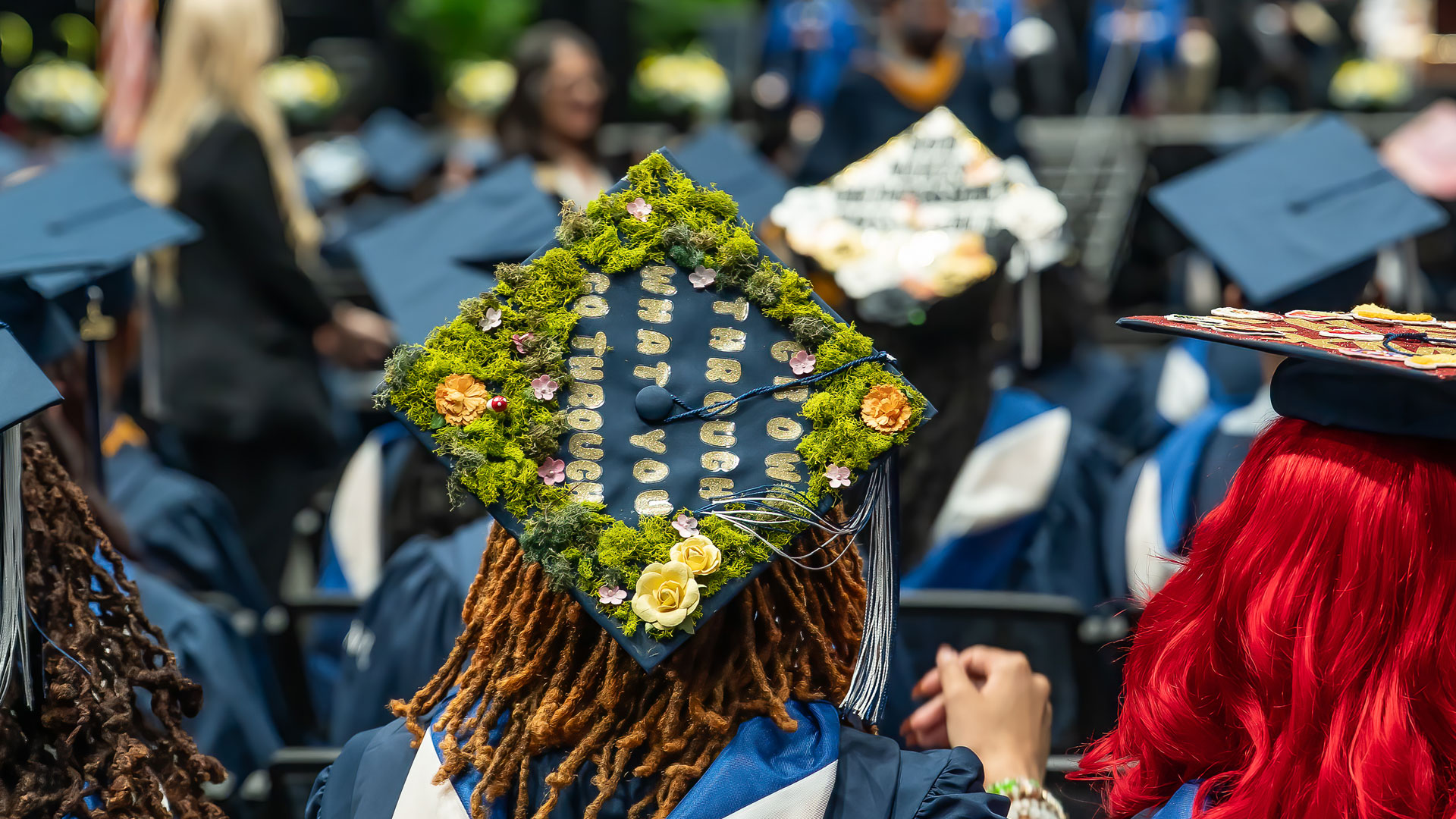 Closeup of a decorated mortarboard reading, “Grow through what you go through.”