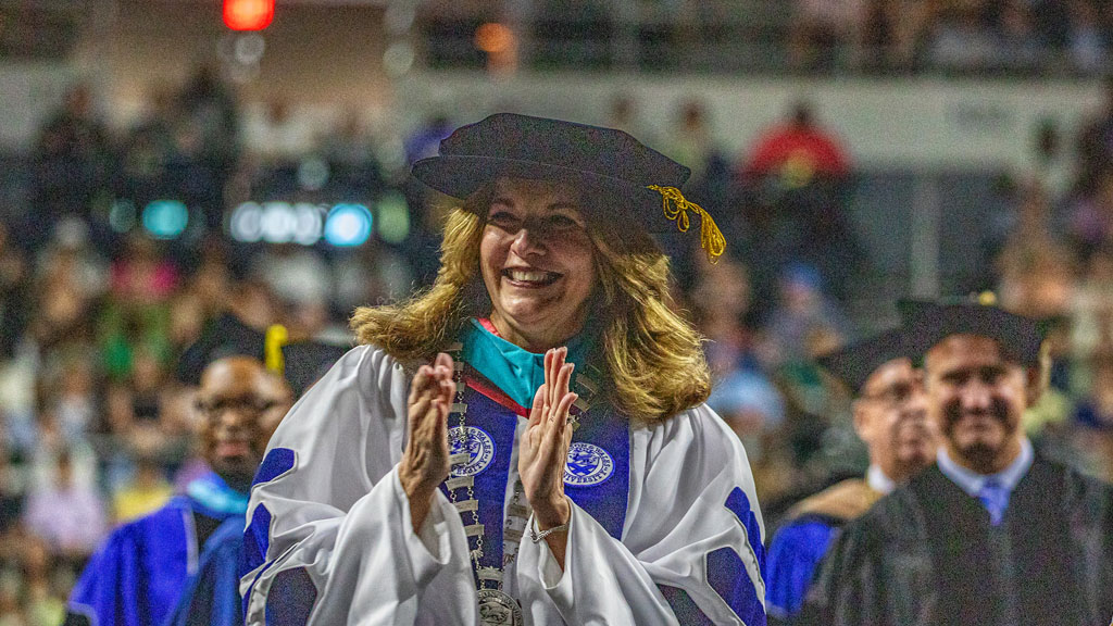 Providence Campus President Marie Bernardo-Sousa claps during the procession.