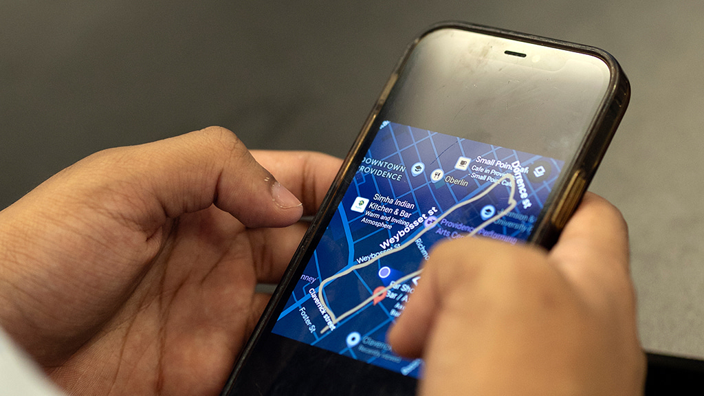 Close-up shot of hands holding iPhone showing a map of Providence