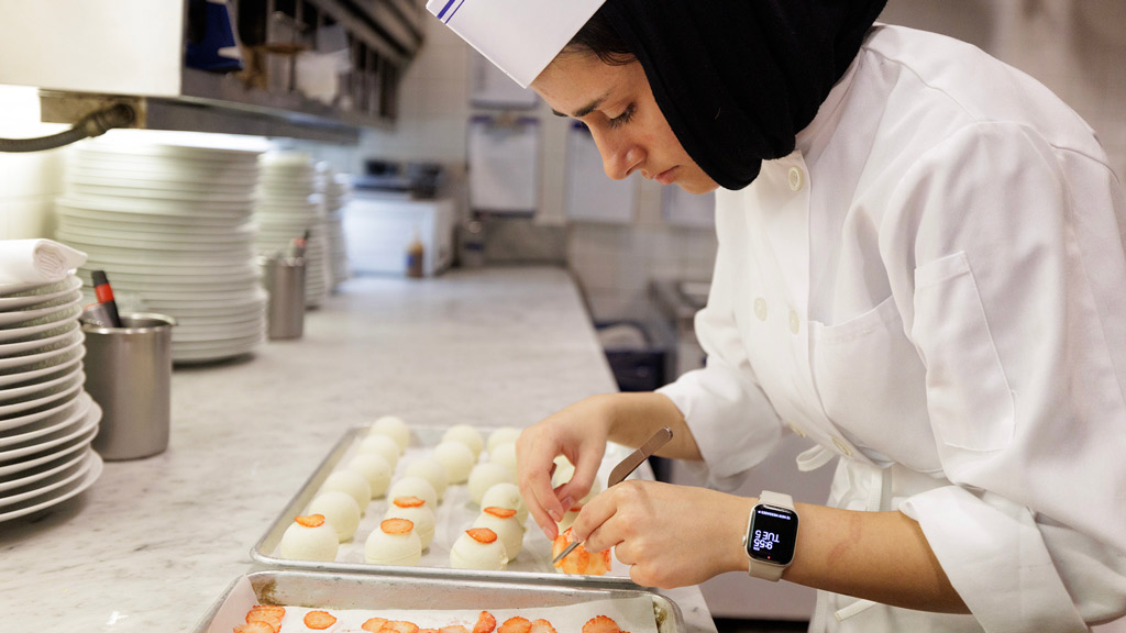 photo of Fatima Khan '27 preparing a tray of desserts