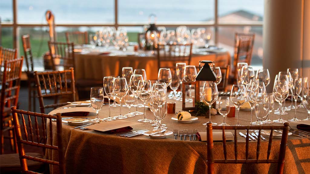 A table with glasses and silverware at a Epicurean event.